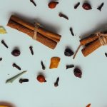 Warm vs. Fresh Fragrances: Which Is Right for Your Home? A flat lay of cinnamon sticks, cloves, and orange slices, perfect for culinary themes.