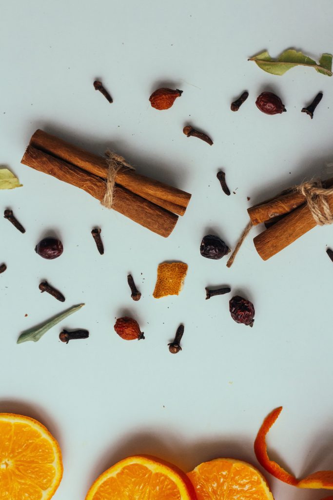Warm vs. Fresh Fragrances: Which Is Right for Your Home? A flat lay of cinnamon sticks, cloves, and orange slices, perfect for culinary themes.