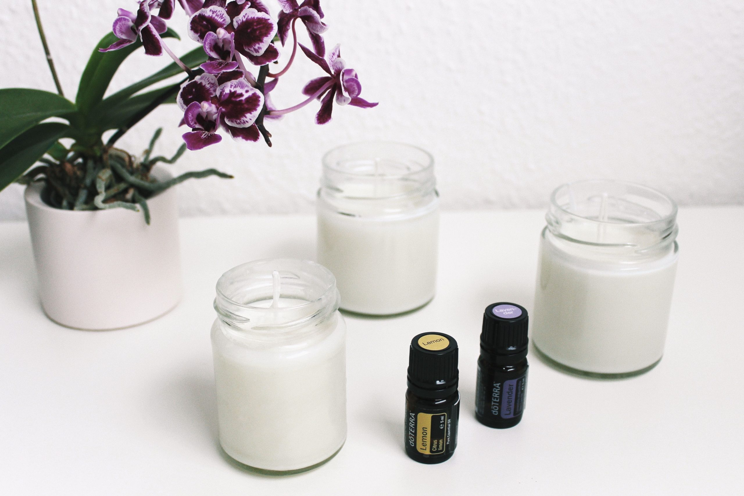 How Fragrance Can Change Your Mood and Transform Your Space A serene setup with candles, essential oils, and orchids creating a calming ambiance.